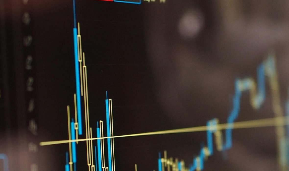 Detailed view of financial trading graphs on a monitor, illustrating stock market trends.